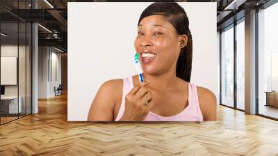 pretty young woman brushing teeth. isolated on a light background Wall mural