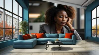 A concerned African American businesswoman deep in thought while sitting in an office Wall mural