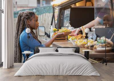 Calm afro american woman getting guacamole and nachos from a fast food truck: Selective focus Wall mural