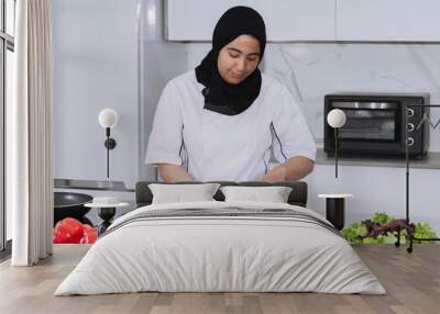 Maghrebi woman with a hijab cutting mushrooms Wall mural