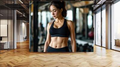 Fit woman in black sportswear working out in modern gym Wall mural