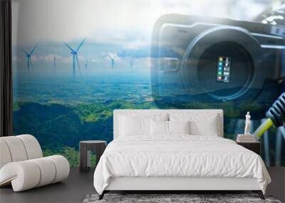 Charge EV car vehicle electric battery on station with wind turbine blue sky on panoramic background. Idea nature electric energy technology green eco car environment friendly concept. Double exposure Wall mural