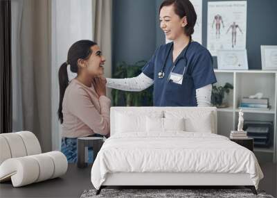 Everythings going to be okay. Shot of a young female doctor comforting a patient in an office. Wall mural