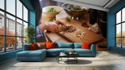 Cooking, hands and salad chop in a home with diet, nutrition and healthy food with person. Kitchen, knife and leaves for organic and vegan lunch with bowl and wood board in a house with wellness Wall mural