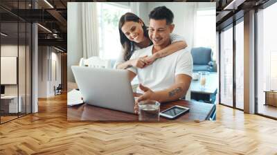 Our financial future looks bright. Cropped shot of an affectionate young couple using a laptop to their household budget in the living room at home. Wall mural