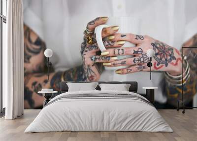 She loves her tattoos. Shot of an unrecognizable tattooed businesswoman holding a mug. Wall mural