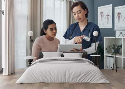 These are all the possible causes. Shot of a young female doctor talking to a patient in an office. Wall mural