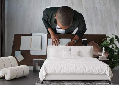 Working my butt off. Shot of a young businessman typing on his laptop while working from home. Wall mural