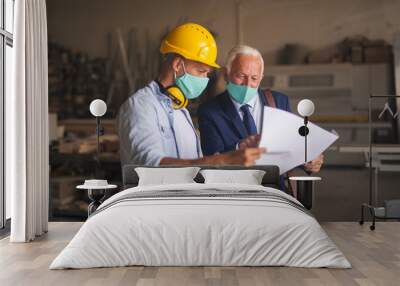 Engineer explaining blueprint to a contractor Wall mural