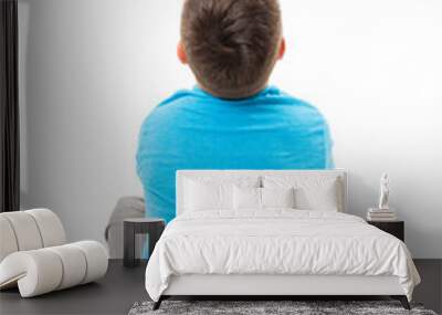  Back view of little boy sitting on floor looking at wall. Rear view. Isolated on white background  Wall mural