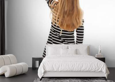 Back view of little girl points at wall. Rear view. Isolated on white background  Wall mural