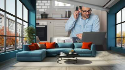 Man putting headphones for an online meeting. Wall mural