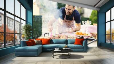 Young man making barbecue Wall mural