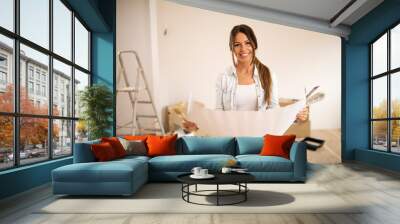 Young woman holding blueprint. Wall mural