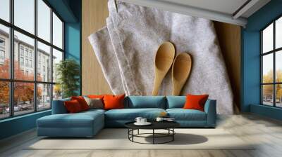 Linen dish cloth and wooden spoons. Top view. Wall mural