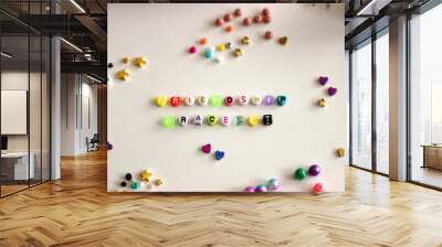 Making friendship bracelets with letter beads. Jewelry making supplies on the table. Selective focus. Wall mural