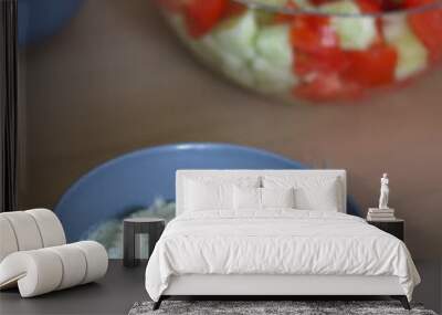 Two bowls of pasta with zucchini sauce and a bowl of cucumber and tomato salad. Selective focus. Wall mural