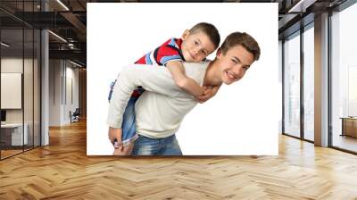 Older boy carries little brother on back isolated on white background Wall mural