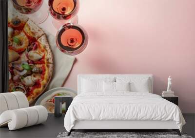 Italian pizza with shells and seafood with 2 glasses of wine on the light pink background with copy space Wall mural