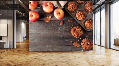 Autumn corner border with warm apple caramel muffins. Top view table scene on a rustic wood background. Copy space. Wall mural