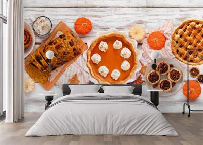 Autumn desserts table scene with a selection of traditional fall sweet treats. Overhead view over a white wood banner background. Wall mural