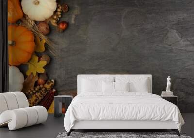 Autumn harvest side border with pumpkins, leaves and nuts over a slate stone background Wall mural