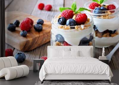 Blueberry and raspberry parfaits in mason jars, scene on a rustic wood background Wall mural