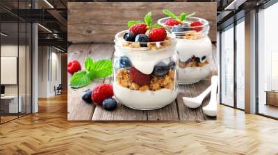 Blueberry and raspberry parfaits in mason jars, still life against a rustic wood background Wall mural