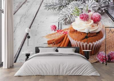 Christmas gingerbread cupcake with frosty cranberries. Close up on a white wood table background with snowy branches. Wall mural