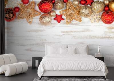 Christmas top border of red and gold ornaments. Overhead view on a white rustic white wood banner background. Copy space. Wall mural