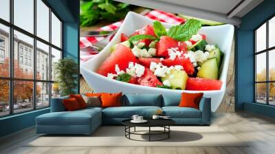 Delicious watermelon, cucumber and feta cheese salad in square bowl on wood background Wall mural