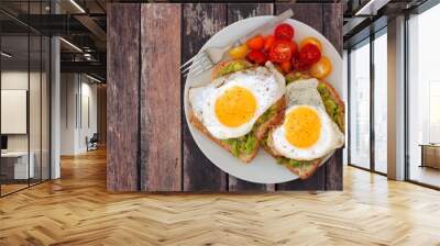 healthy avocado, egg open sandwiches on a plate with colorful tomatoes against rustic wood Wall mural