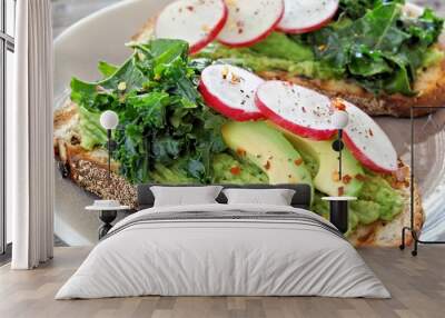 Healthy avocado toast close up with kale and radish on whole grain bread Wall mural