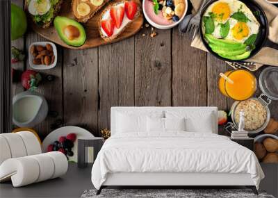 Healthy breakfast food frame. Table scene with fruit, yogurt, smoothie, oatmeal, nutritious toasts and egg skillet. Top view over a rustic wood background. Copy space. Wall mural