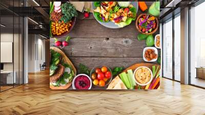 Healthy lunch food frame. Table scene with nutritious Buddha bowl, lettuce wraps, sandwiches, salad and vegetables. Overhead view over a rustic wood background. Copy space. Wall mural