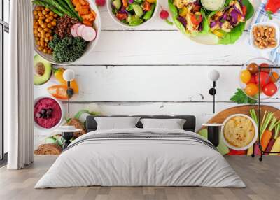 Healthy lunch food frame. Table scene with nutritious Buddha bowl, salad, lettuce wraps, vegetables and sandwiches. Top view over a white wood background. Copy space. Wall mural