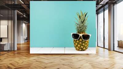 Hipster pineapple with trendy sunglasses against turquoise background. Minimal summer concept. Wall mural