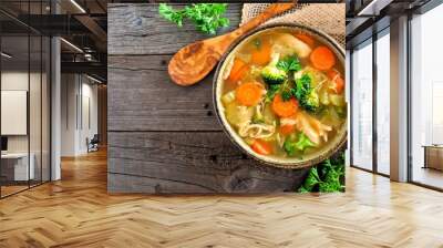 Homemade chicken vegetable soup, above view with copy space on a rustic wooden background Wall mural