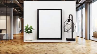 Mock up black frame, succulent plant and industrial style lamp on a shelf or desk. White shelf and wall. Portrait frame orientation. Wall mural