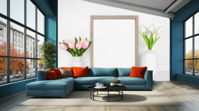 Mock up wood frame with spring tulip flowers. White shelf against a white wall. Copy space. Wall mural