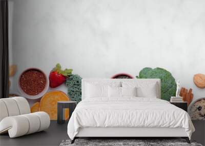 Set of healthy food ingredients. Top view bottom border on a white banner background. Copy space. Super food concept with green vegetables, berries, whole grains, seeds, spices and nutritious items. Wall mural