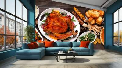 Traditional Thanksgiving turkey dinner. Top view table scene on a dark wood banner background. Turkey, mashed potatoes, dressing, pumpkin pie and sides. Wall mural