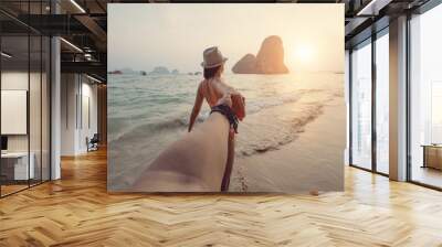 Girl in a bikini holding a guy's hand on the beach Wall mural