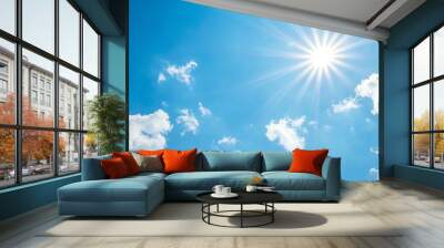 Bright sun shining in a clear blue sky with fluffy white clouds. Wall mural