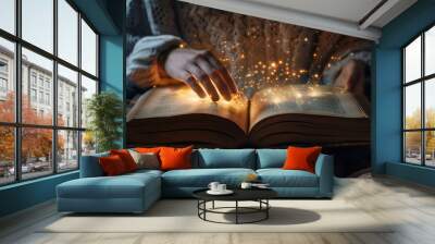 Hands touching a magical glowing book with sparks. Concept of magic, wonder, and fantasy in literature. Wall mural