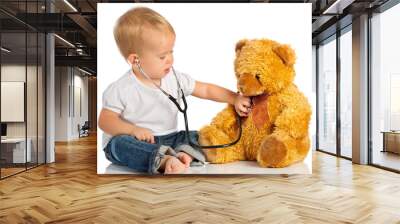 baby plays in doctor toy bear and stethoscope Wall mural