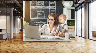 Businesswoman mother  woman with toddler working at computer. Wall mural