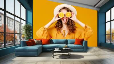 cheerful young curly woman girl with   orange   on  yellow   background Wall mural