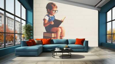 child little girl with glasses reading a books Wall mural