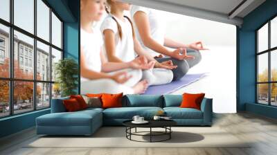 children practicing yoga in a lotus pose with  teacher Wall mural